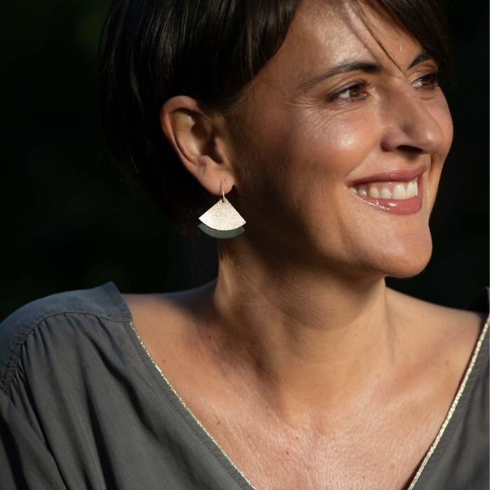 Une femme porte des boucles d'oreilles éventail écoresponsable kaki