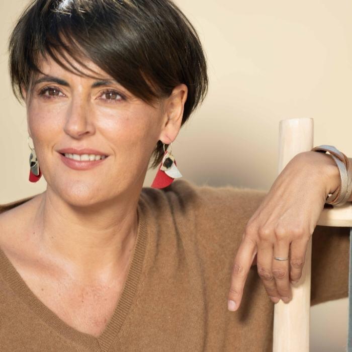 “Femme avec des yeux noisette sublimée avec des boucles d’oreilles en cuir rouge et léopard Carole & Co