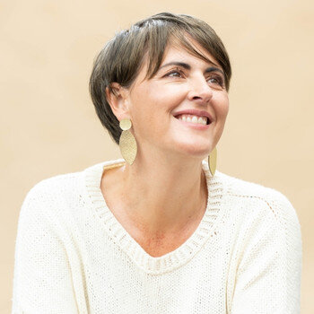 une femme porte des boucles d'oreilles adeline pour les noces de cuir