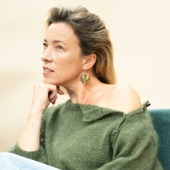 Femme assise porte des Boucles adaptées à ma colorimétrie